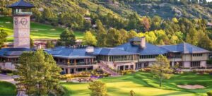 Clubhouse and golf course surrounded by trees at the Castle Pines Golf Club