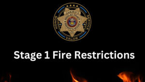 Sheriff's badge with text that reads Stage 1 Fire Restriction.